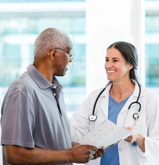 An older man talks to his provider about possible cancer treatments.