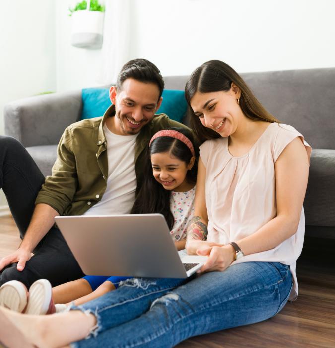 Family gathered around their computer 